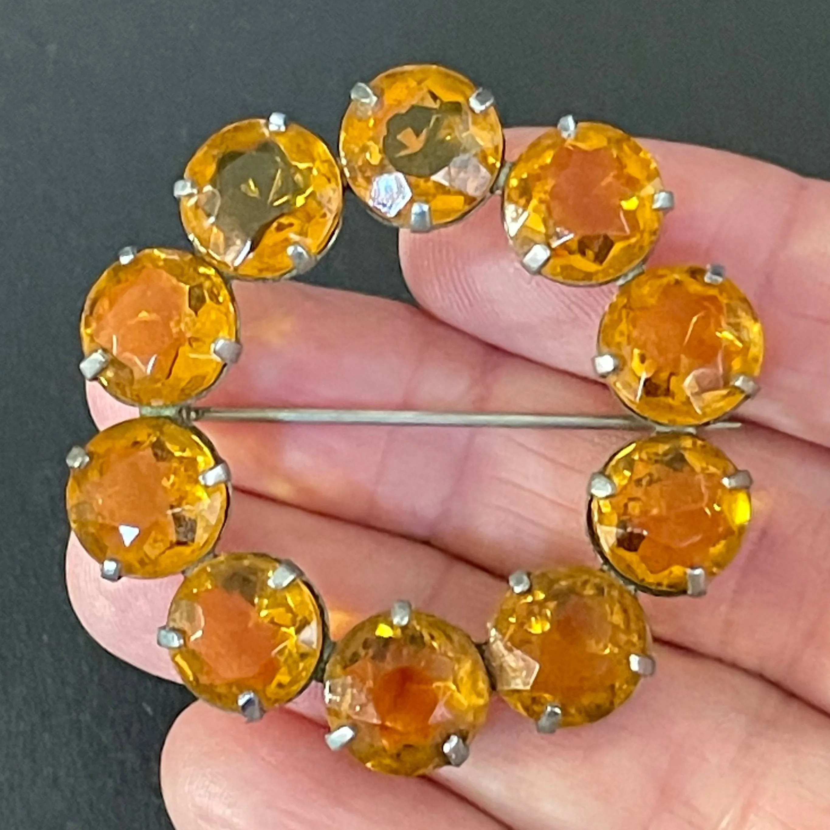 Vintage Art Deco bezel set sunshine coloured citrine yellow / orange crystal riviere circle brooch, open-backed rhinestones in silver tone