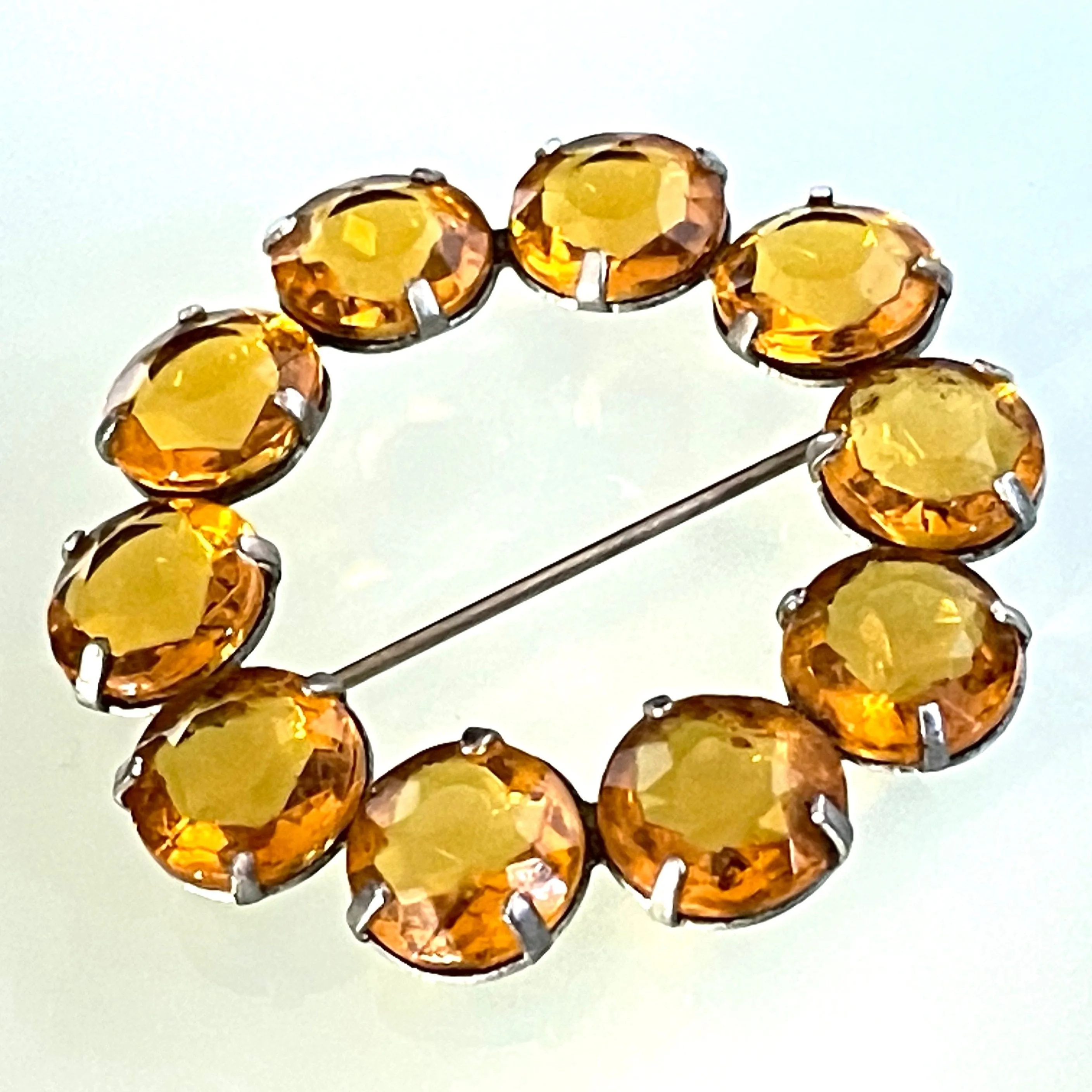 Vintage Art Deco bezel set sunshine coloured citrine yellow / orange crystal riviere circle brooch, open-backed rhinestones in silver tone