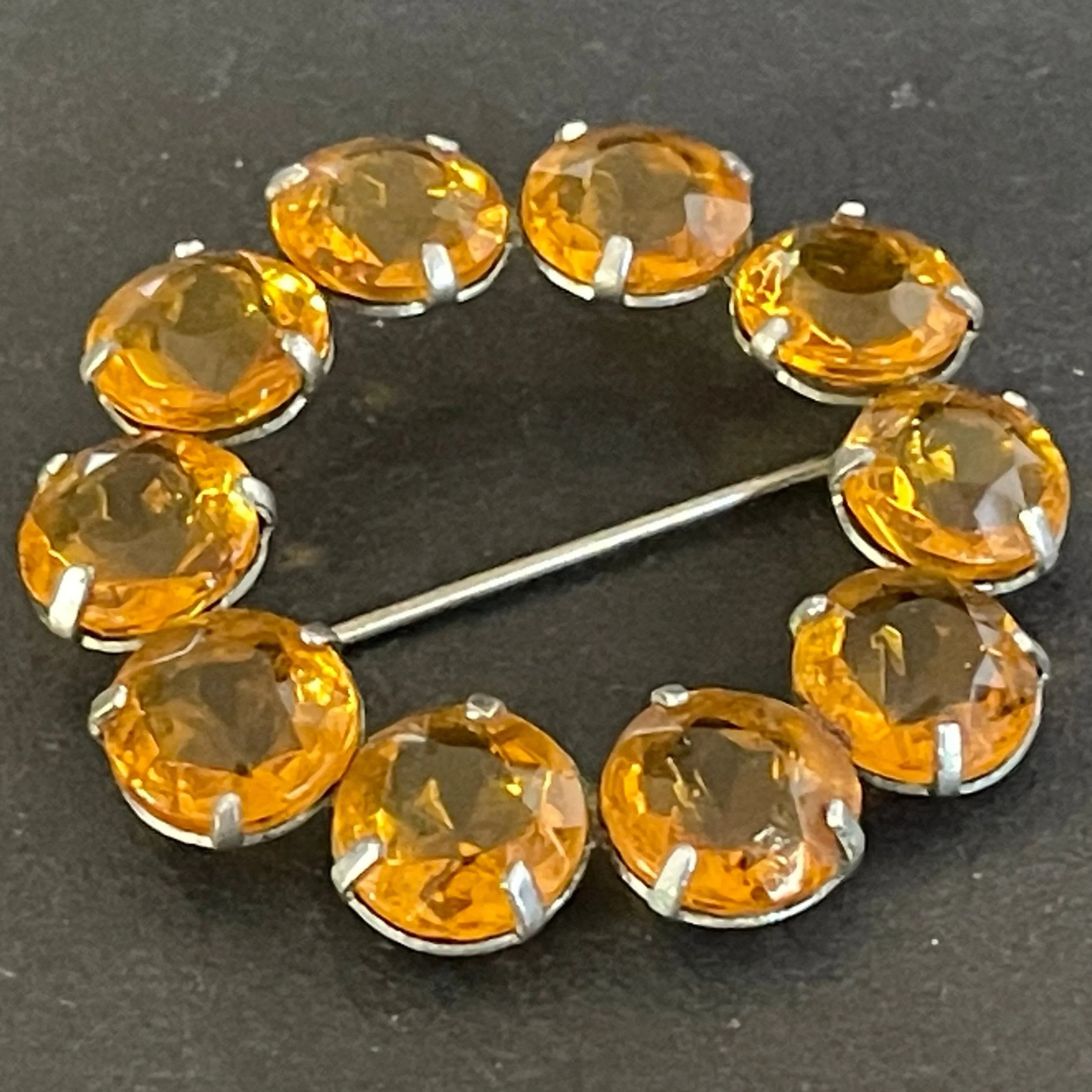 Vintage Art Deco bezel set sunshine coloured citrine yellow / orange crystal riviere circle brooch, open-backed rhinestones in silver tone