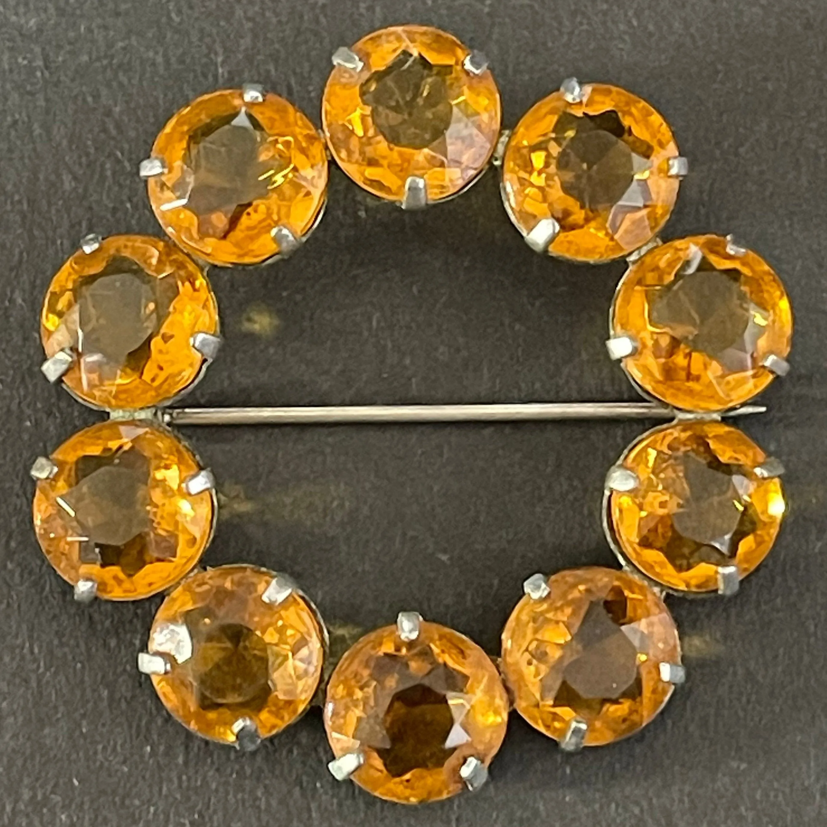 Vintage Art Deco bezel set sunshine coloured citrine yellow / orange crystal riviere circle brooch, open-backed rhinestones in silver tone